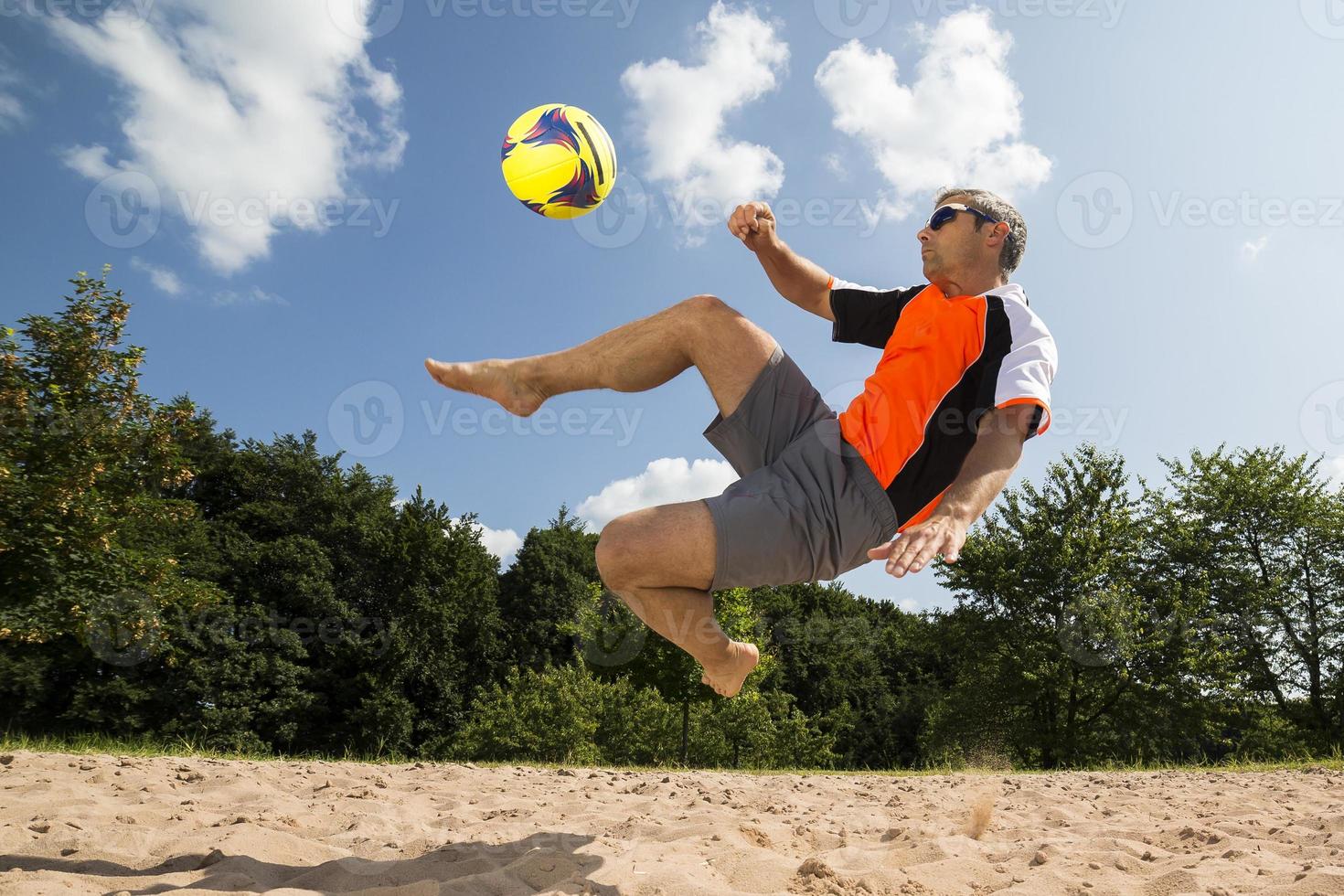 atleta jogando futebol de praia foto