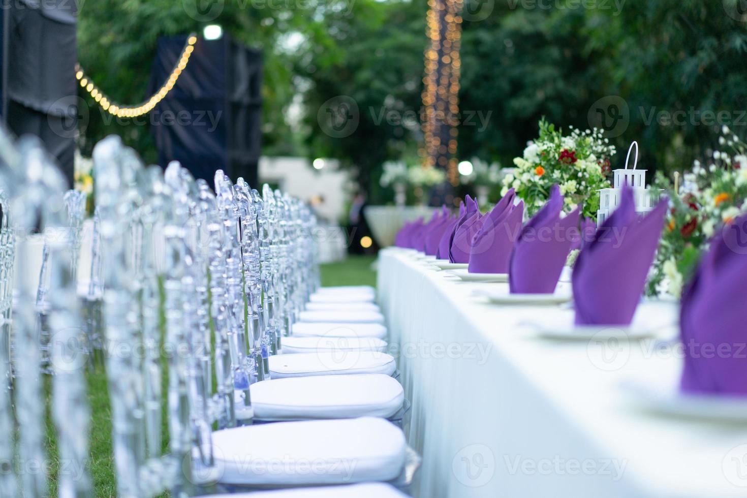 luxo branco - roxo - mesa de jantar vermelha com cadeira de cristal no jardim. foto