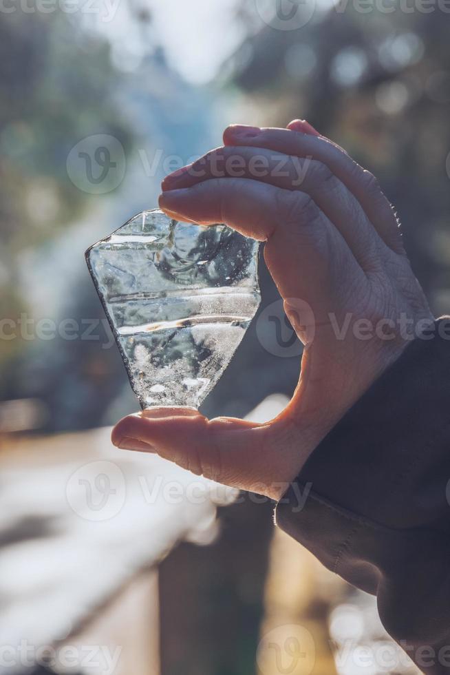 close-up na mão masculina segurando o fragmento de gelo foto