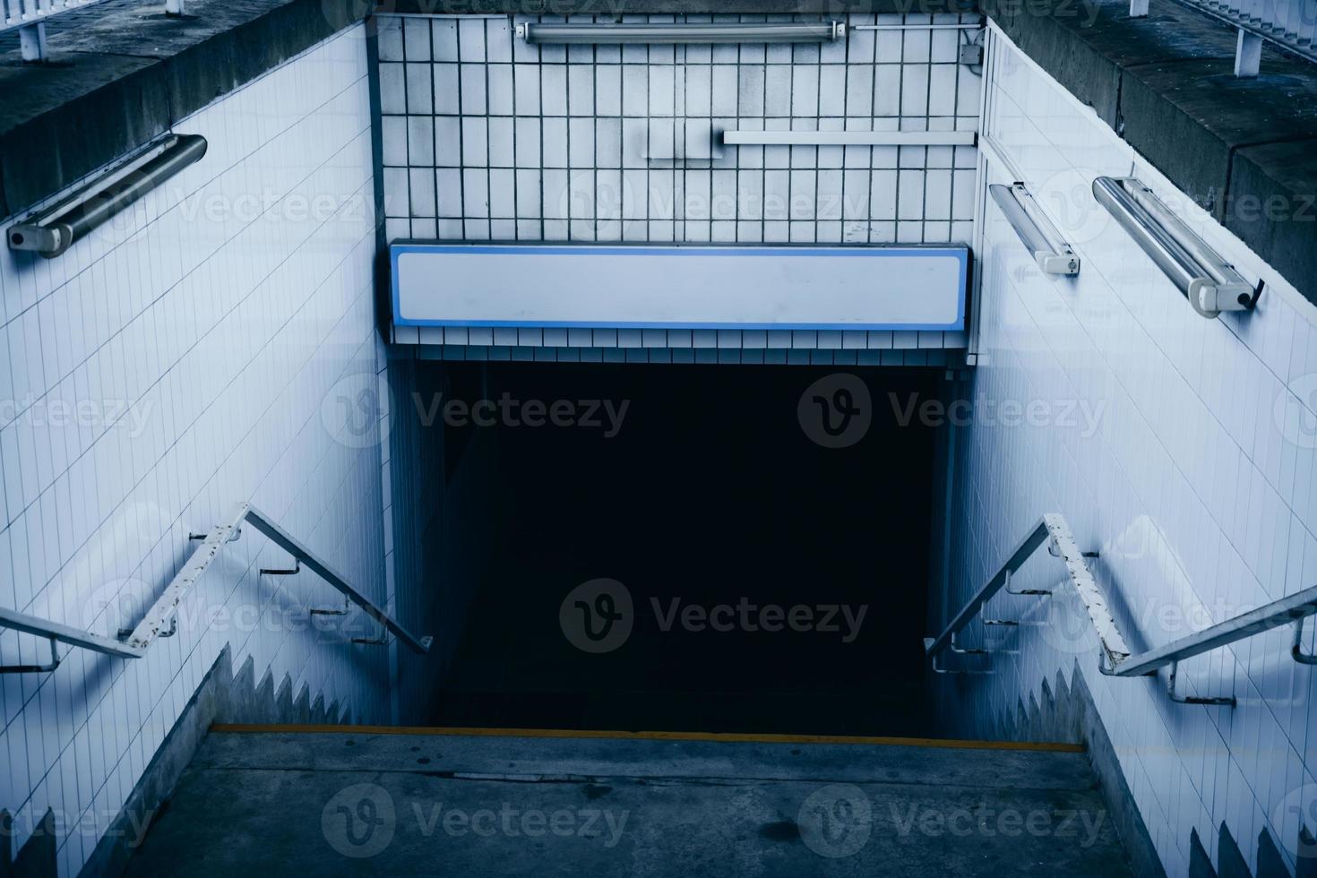 uma passagem subterrânea com escadas em uma estação de trem foto