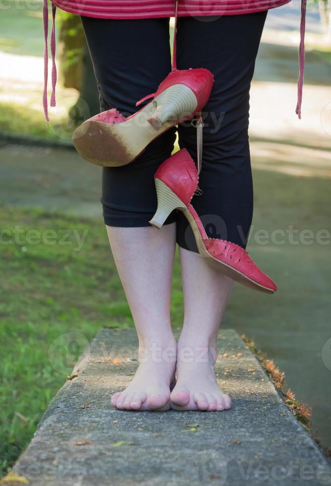 mulher em pé descalço em uma parede foto