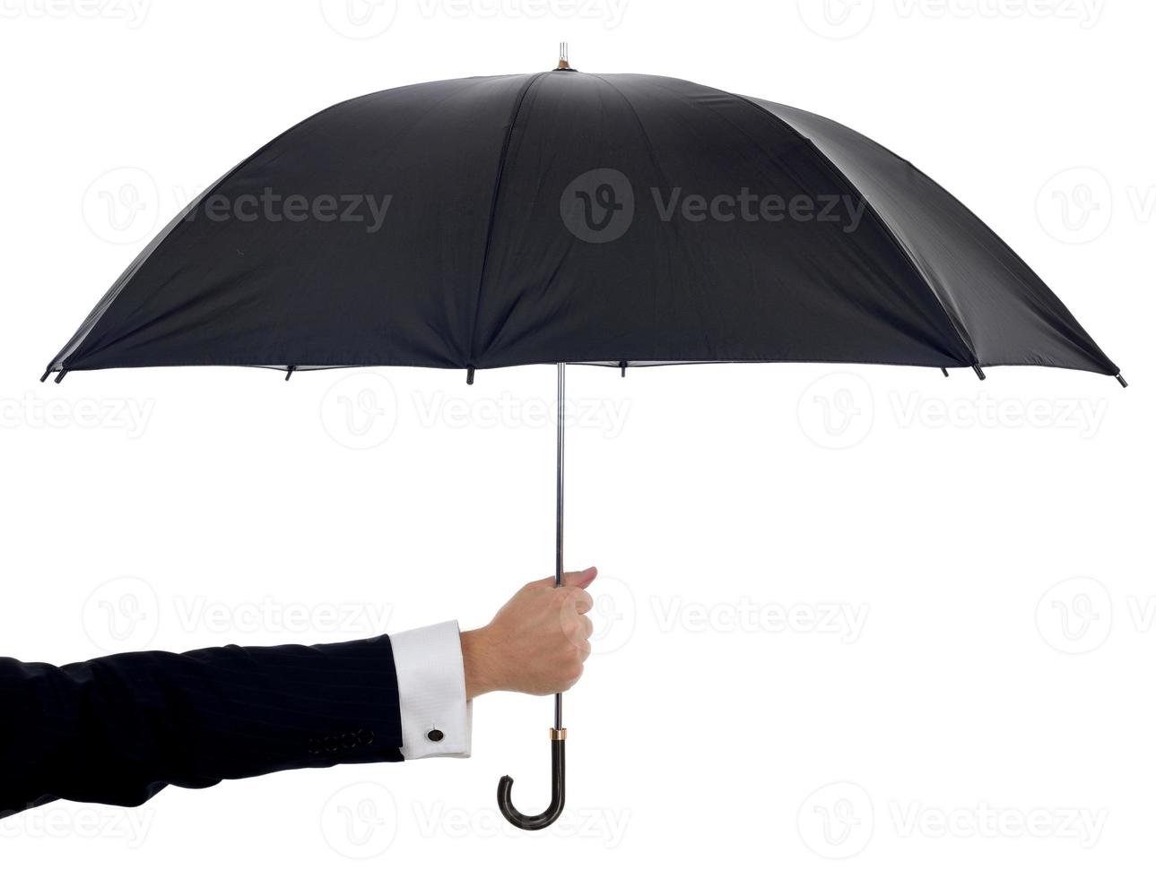 um guarda-chuva preto sobre fundo branco, sustentado por um braço foto