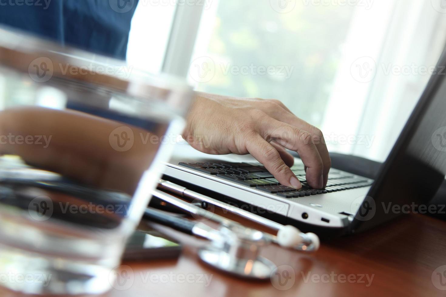 médico trabalhando com tablet digital e computador portátil foto