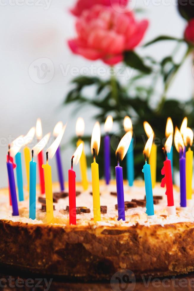 Bolo de aniversário de 18 anos com velas acesas e banner de aniversário de  confete