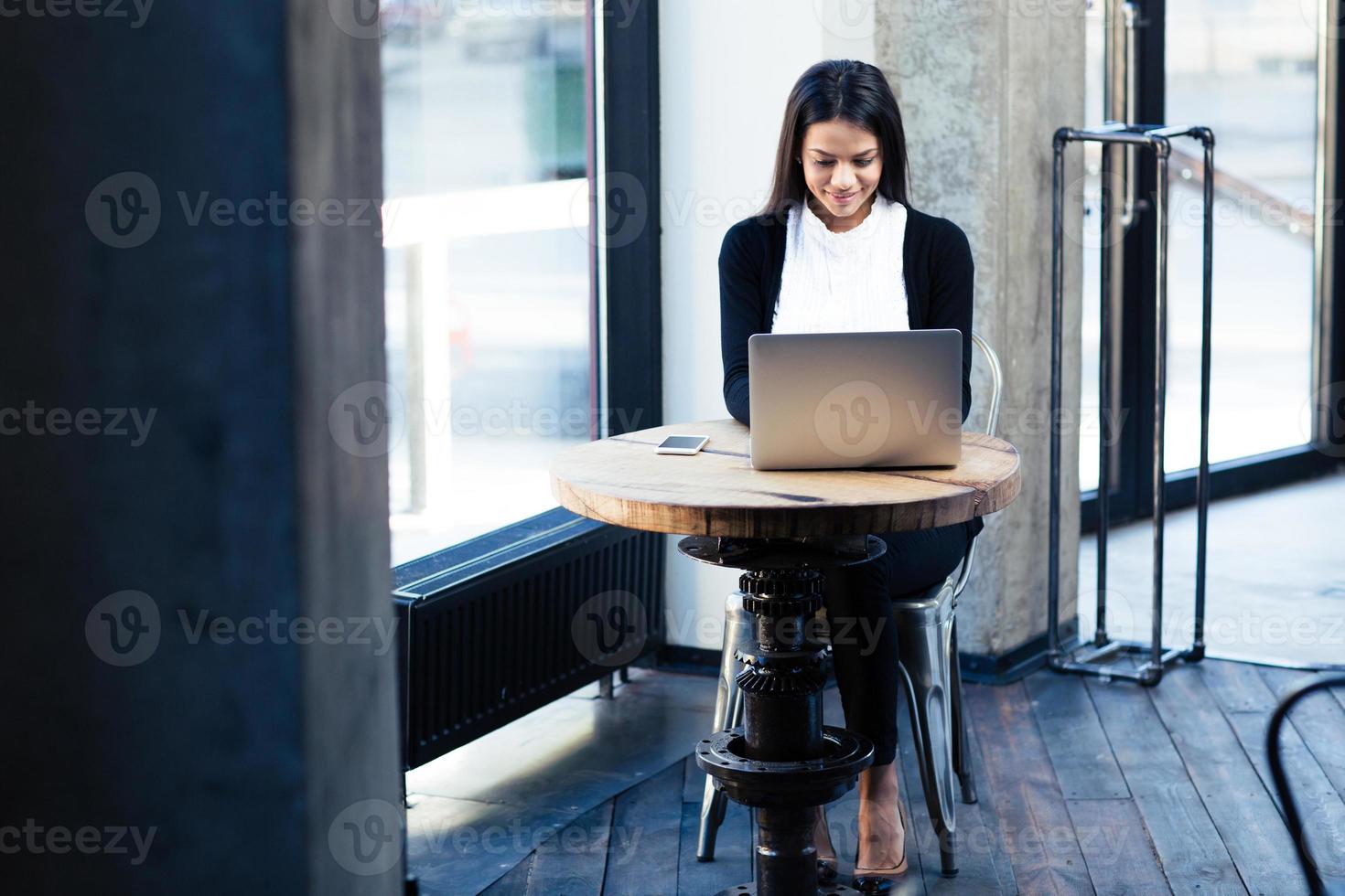 empresária feliz usando laptop no café foto