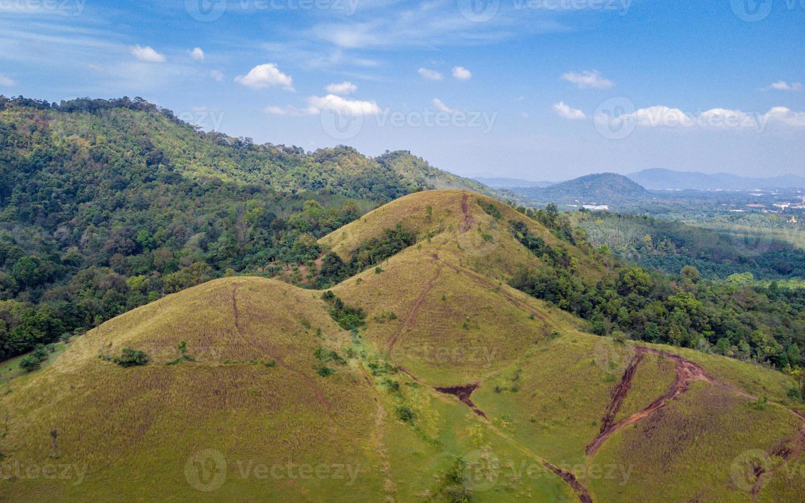 montanha careca ou phu khao ya com campo de grama verde e céu azul. uma das atrações naturais de viagem na província de ranong, tailândia foto