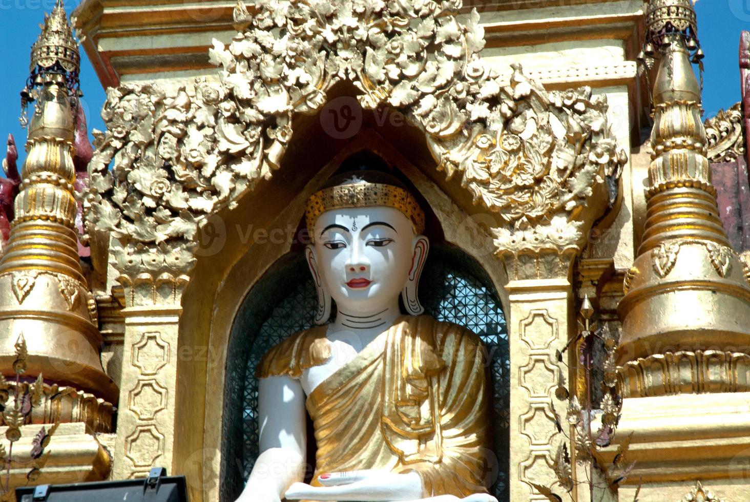 Buda branco no pagode dourado, myanmar. foto