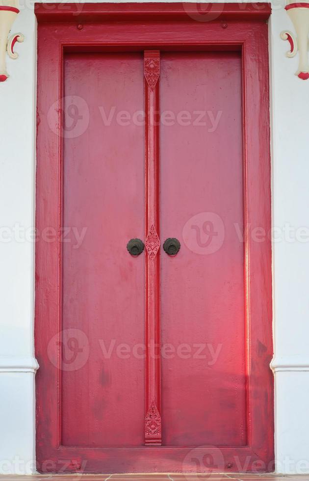 porta de madeira vermelha tailandesa com talha tradicional foto