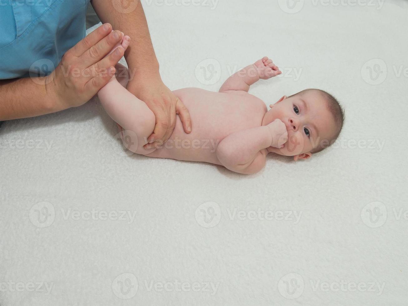 médico massagem pequeno bebê caucasiano foto