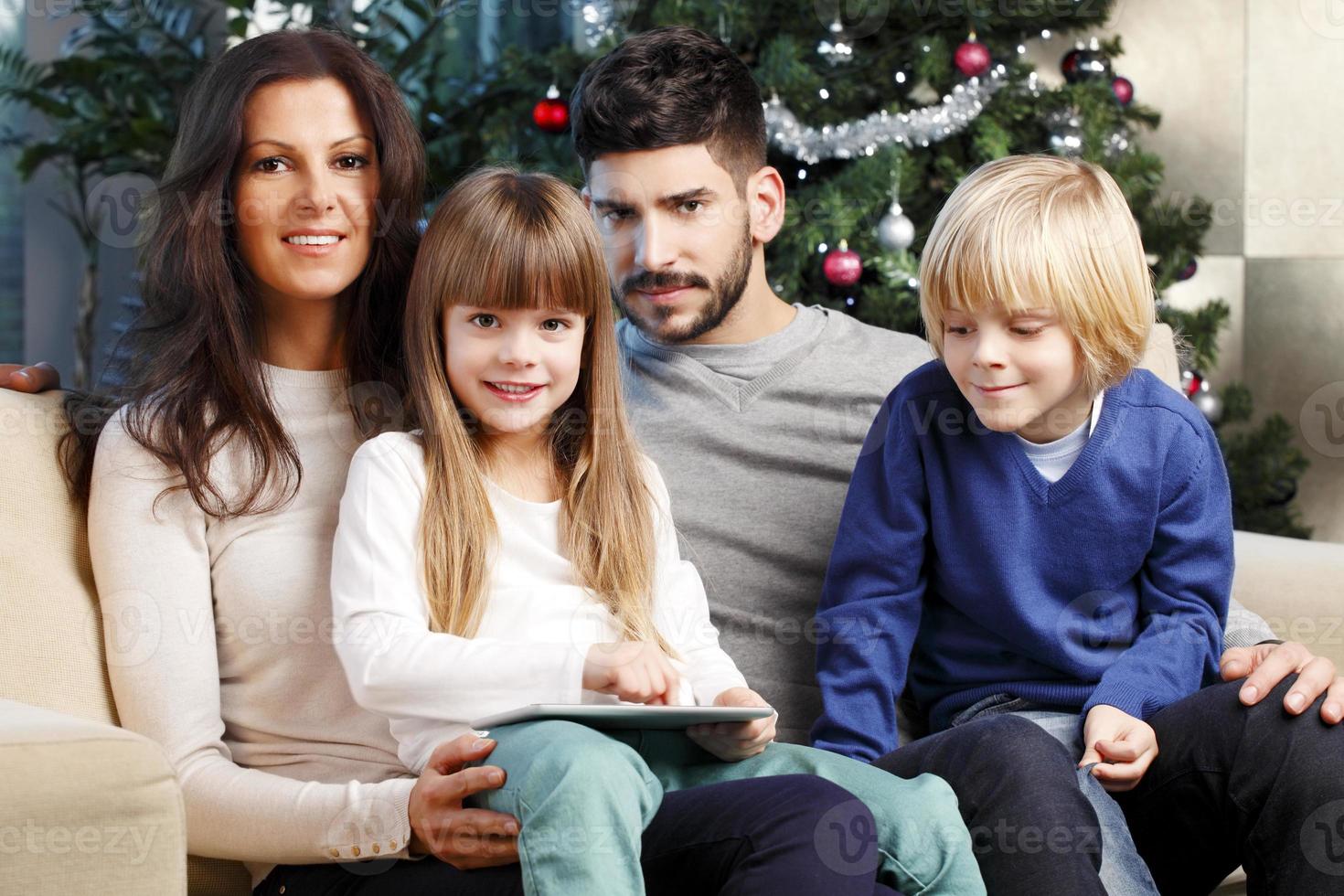 família feliz na árvore de natal foto