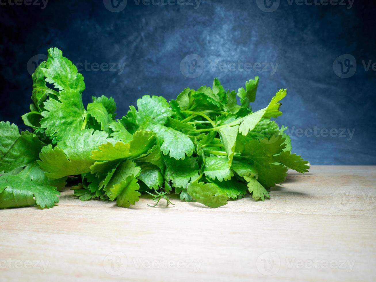 um monte de coentro em uma tábua de corte. produto útil. verdes na mesa da cozinha. ingrediente de almoço vegetariano. muitos talos de coentro. foto