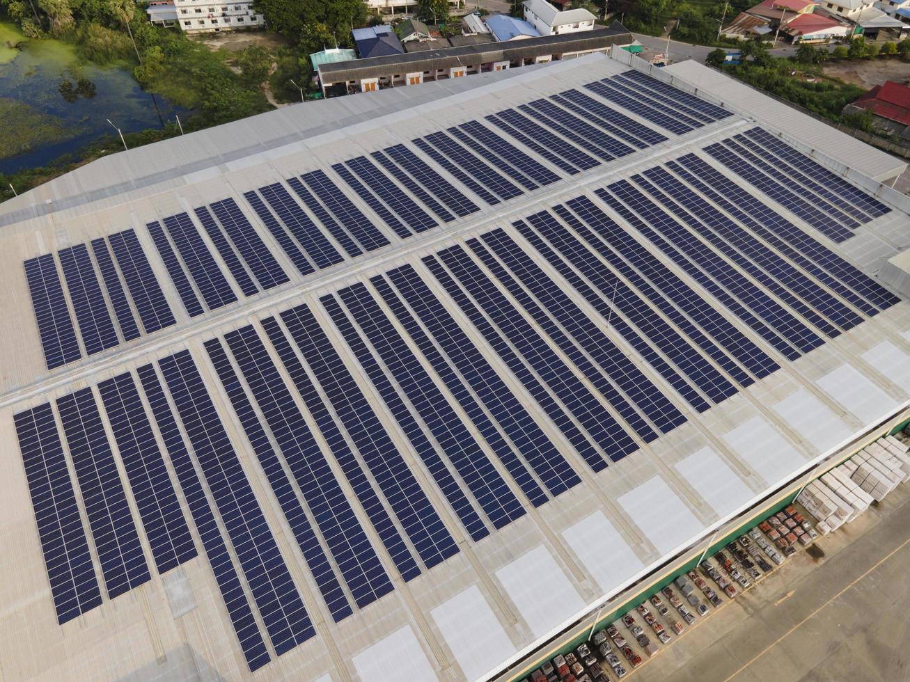imagem de drone aéreo de painéis solares instalados no telhado de um grande edifício industrial ou armazém. edifícios industriais.a energia renovável fontes sustentáveis energia verde fotovoltaica. foto