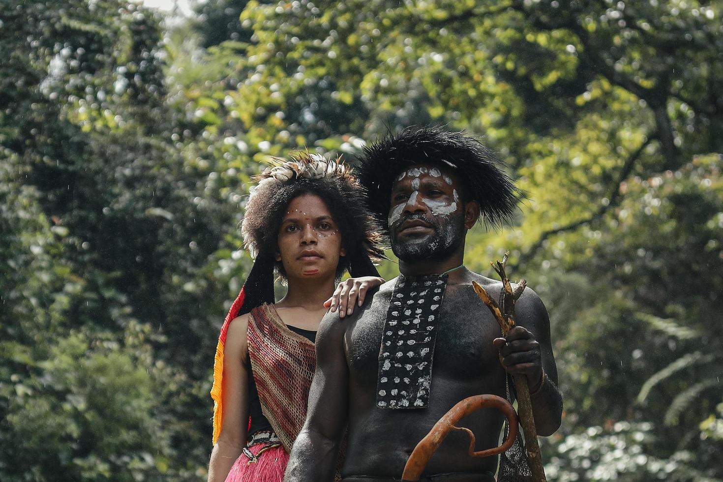 Wamena, Papua, Indonésia, 01 de junho de 2022 close-up de pai e filha da tribo dani em roupas tradicionais juntos, contra o fundo da floresta verde. família papua. foto