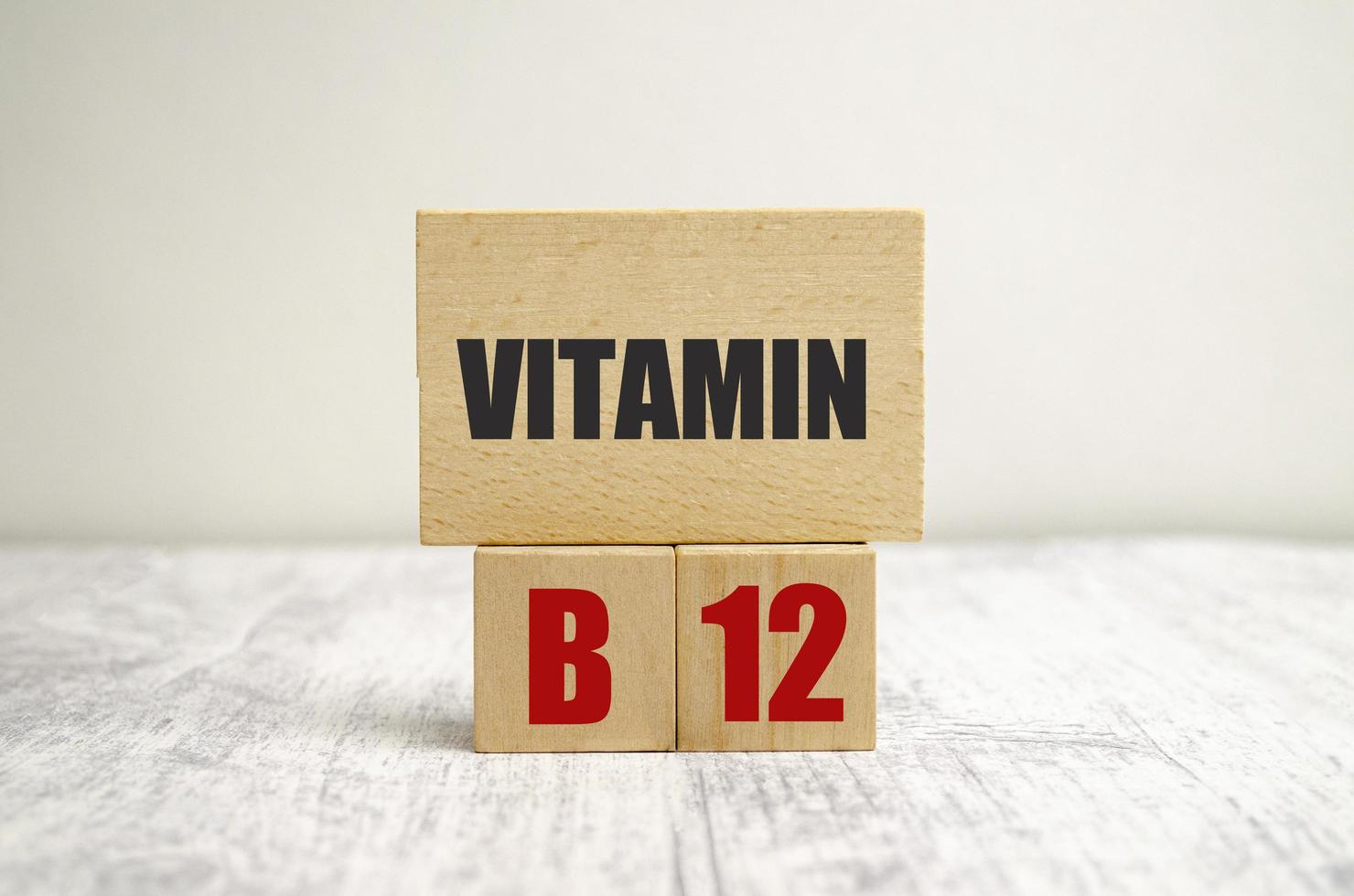 palavras de vitamina b12 em blocos de madeira com fundo de madeira foto