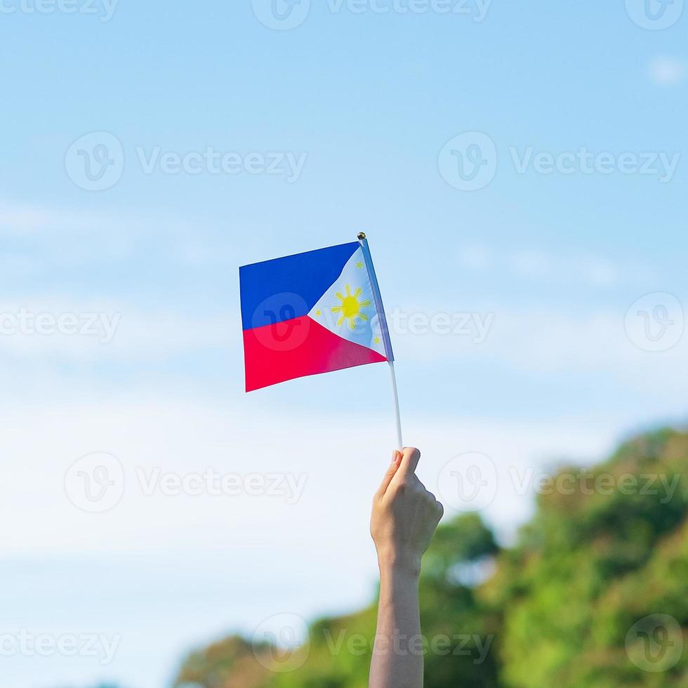 mão segurando a bandeira das filipinas no fundo da natureza. 12 de junho do dia da independência e conceitos de celebração feliz foto