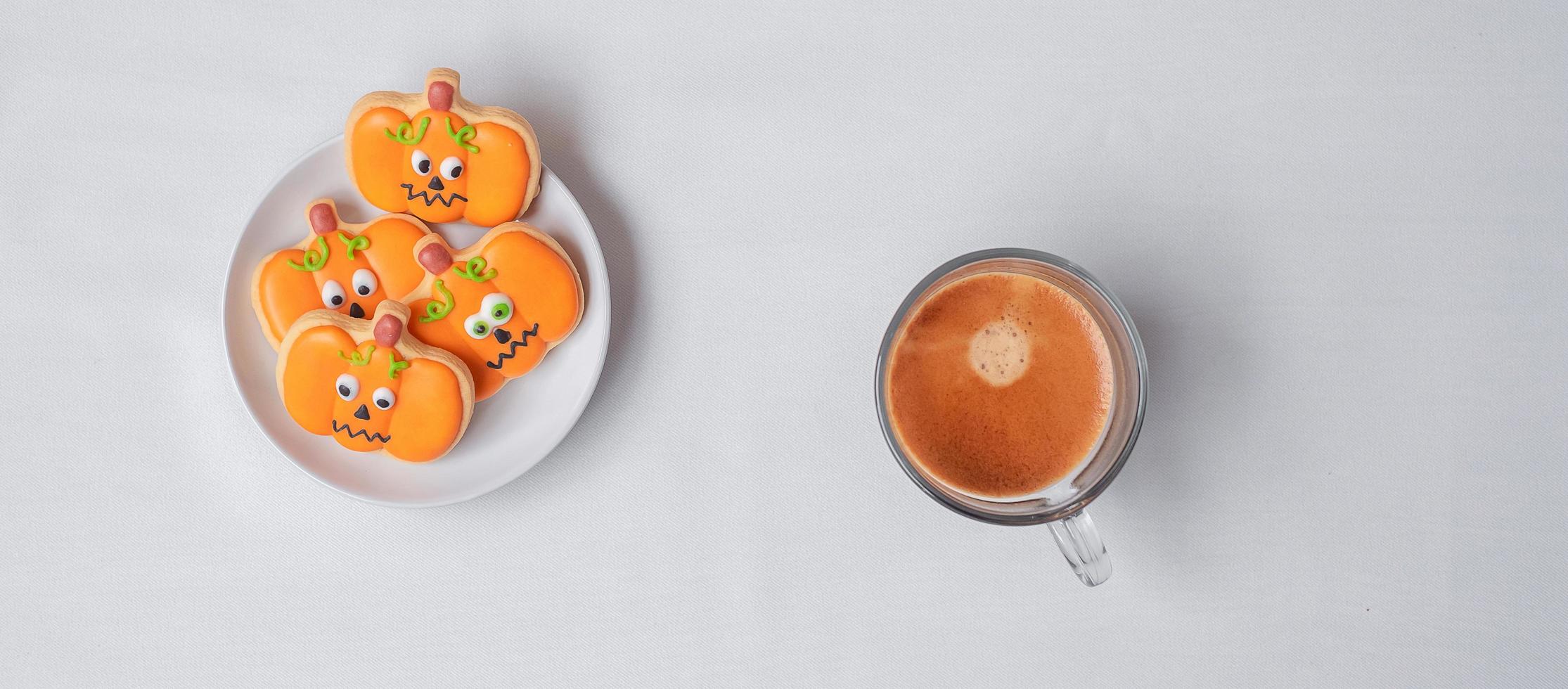 café expresso quente ou xícara de chocolate com biscoitos engraçados de halloween. feliz dia das bruxas, truque ou ameaça, olá outubro, outono outono, tradicional, festa e conceito de feriado foto