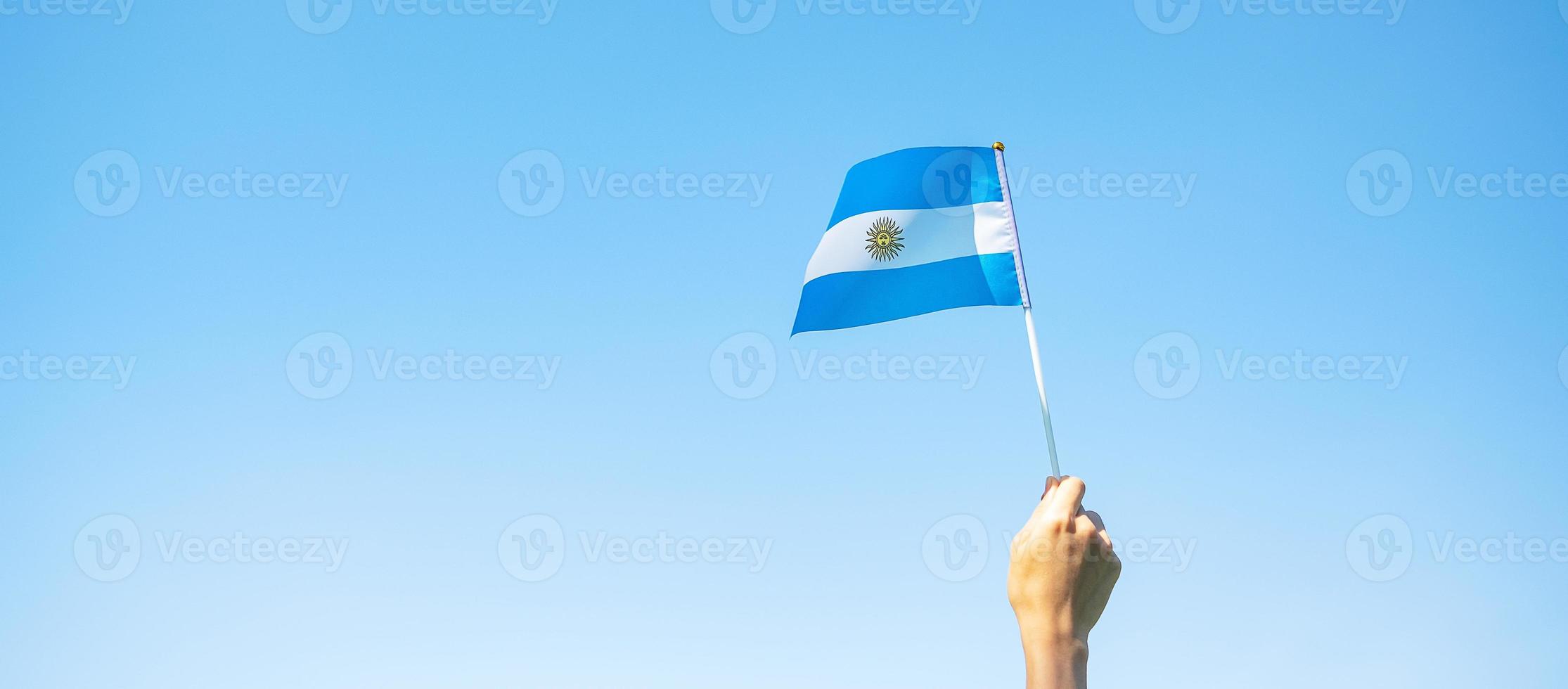 mão segurando a bandeira argentina no fundo da natureza. 9 de julho do dia da independência, 25 de maio do dia da revolução e conceitos de celebração feliz foto