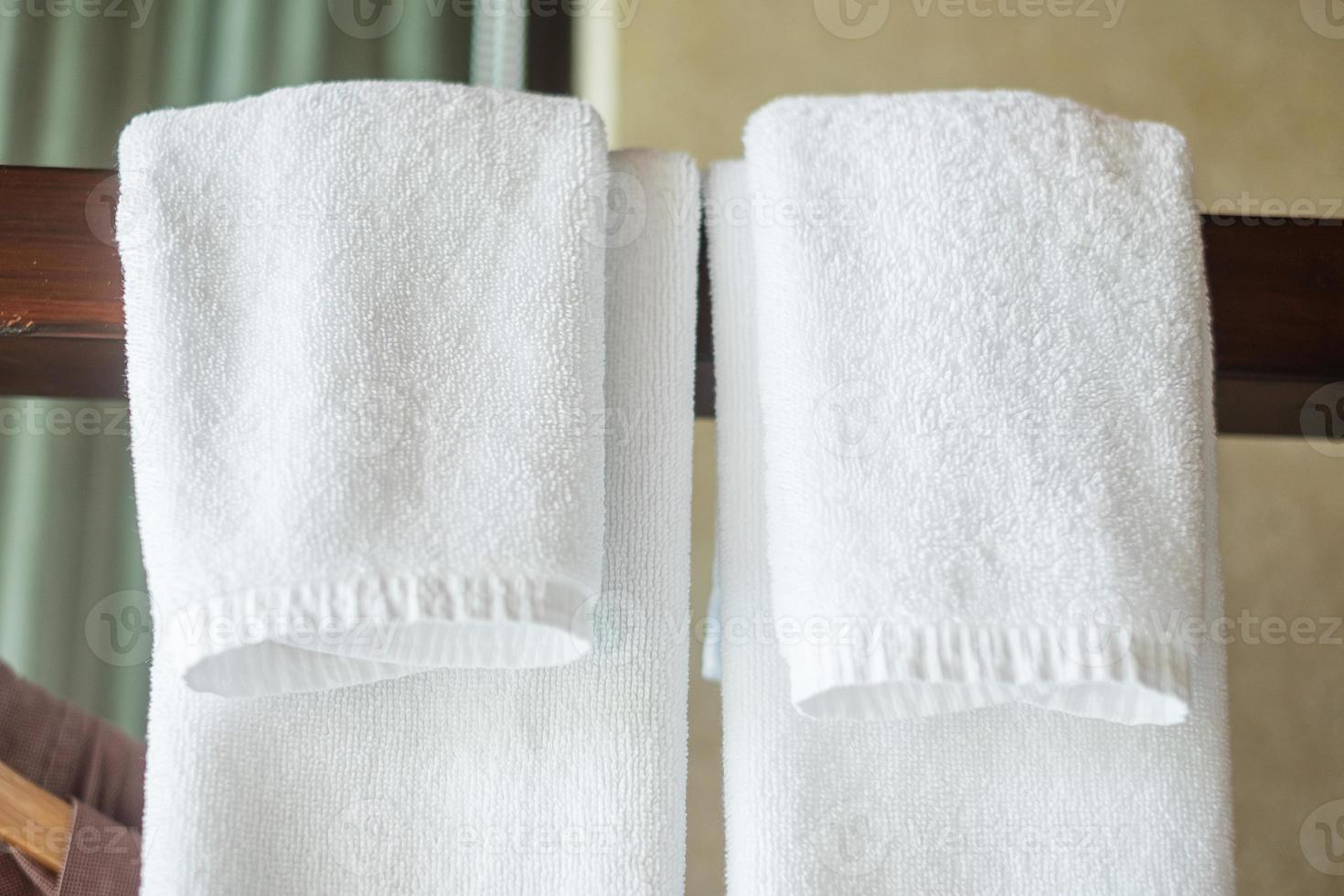 closeup toalha limpa pendurada no guarda-roupa de madeira no hotel de luxo. relaxar e viajar conceito foto