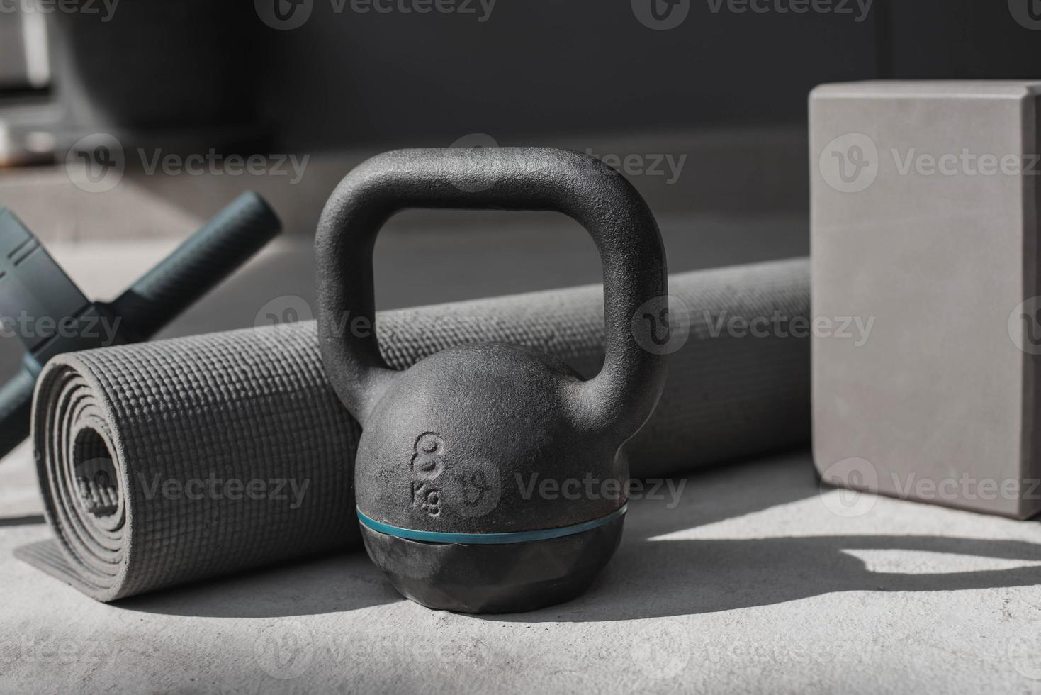 kettlebell e tapete de ioga no chão em casa. Equipamento de ginástica. foto