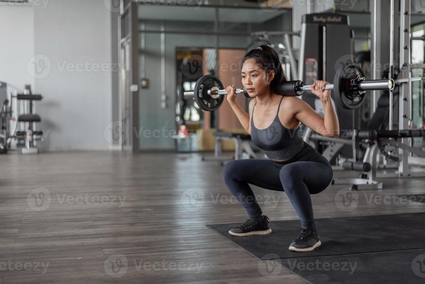 exercício de mulher asiática em fitness. jovem mulher saudável no sportswear fazendo exercícios de pernas em fitness. foto