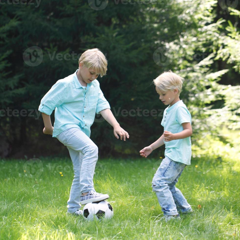 duas crianças jogando futebol foto