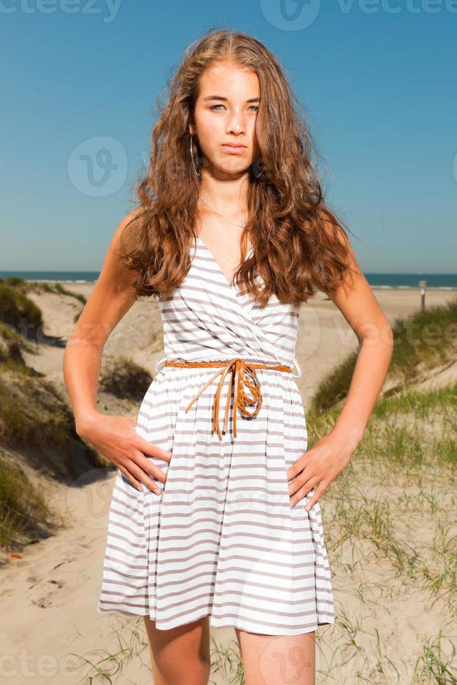 menina bonita feliz com cabelos castanhos compridos, aproveitando a praia. foto