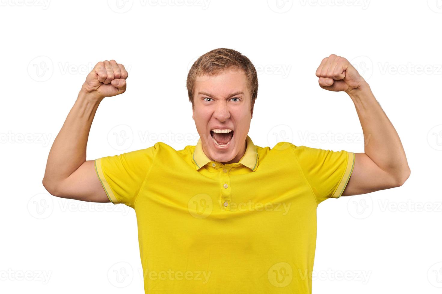 jovem engraçado em camiseta amarela casual, levantando as mãos e regozijando-se com o sucesso, fundo isolado foto