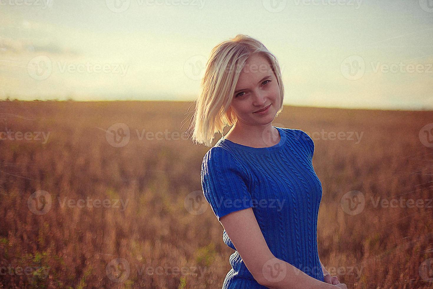 linda garota de pé no campo e olhando para a câmera foto