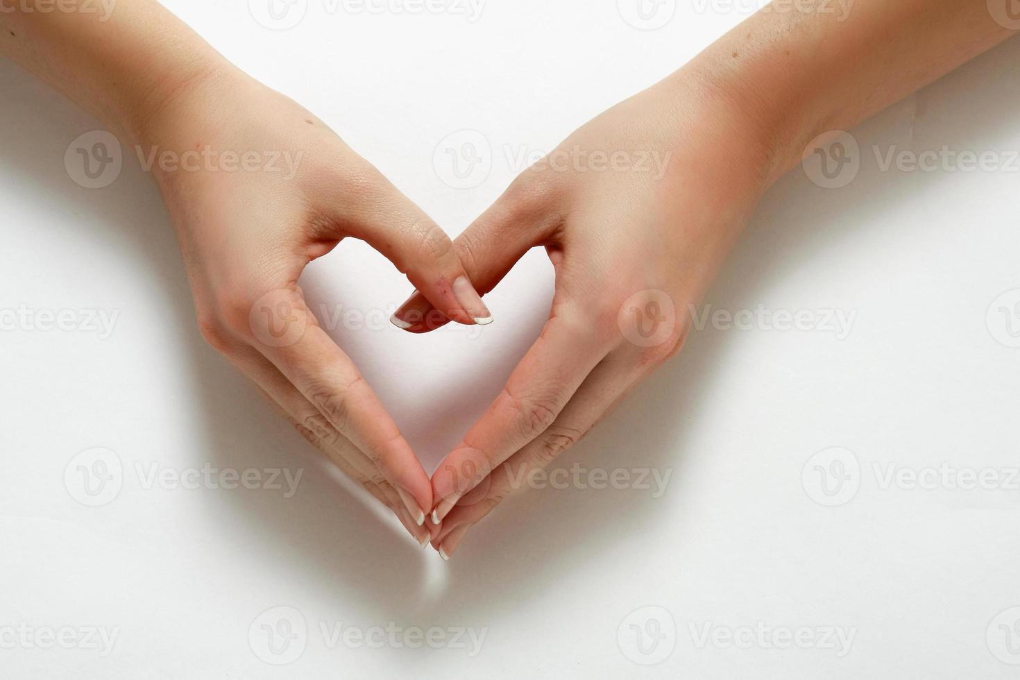 mãos de mulher formando um coração foto
