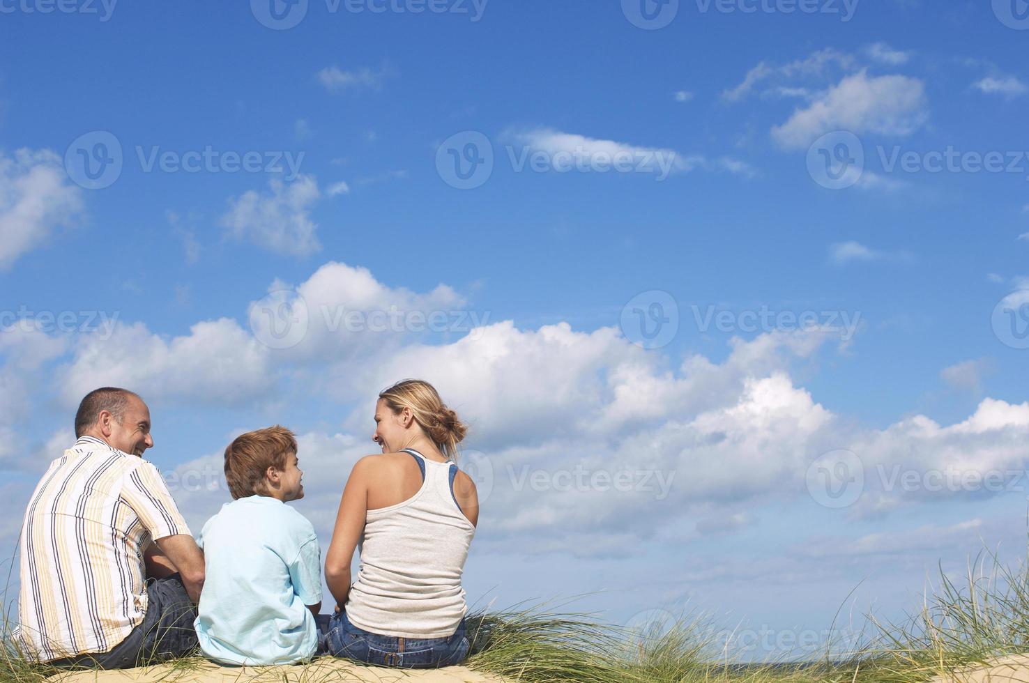 pais e filho, apreciando a vista da praia foto