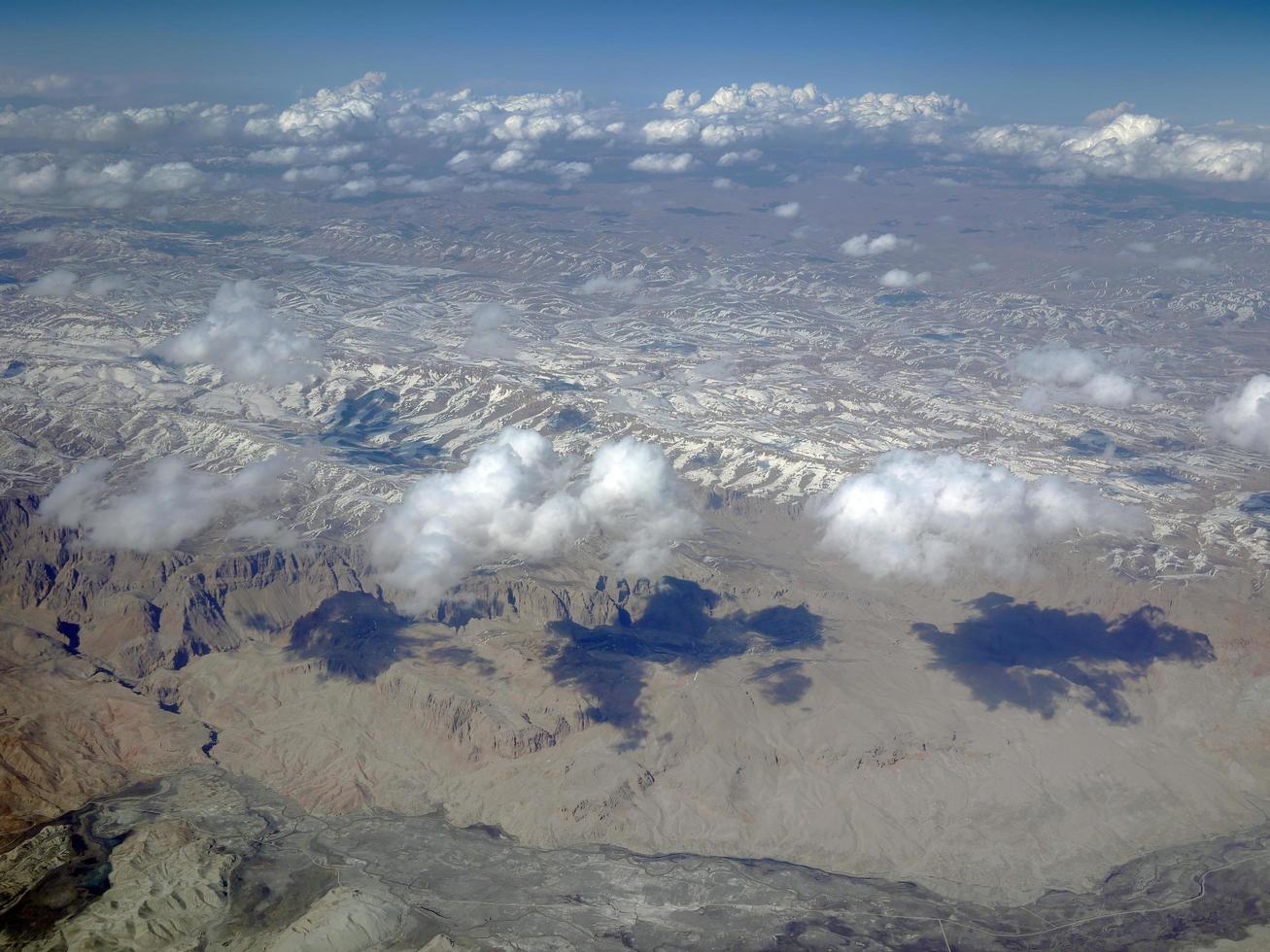 vista aérea das montanhas da paisagem com neve e cloudlscape de cima foto