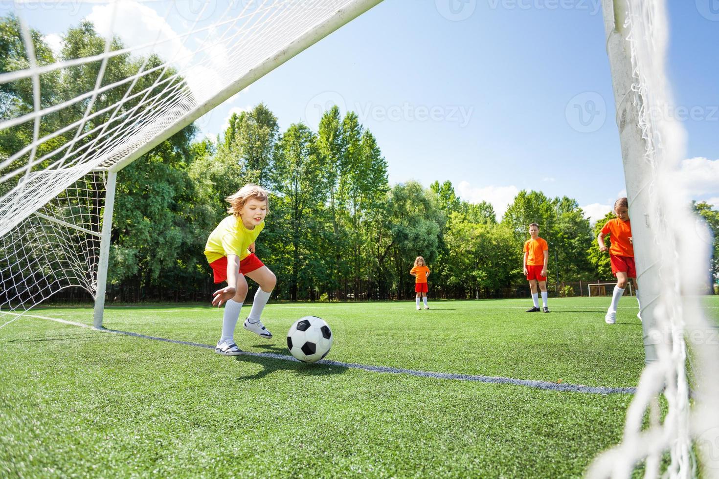 menino tenta pegar futebol jogado em madeira foto