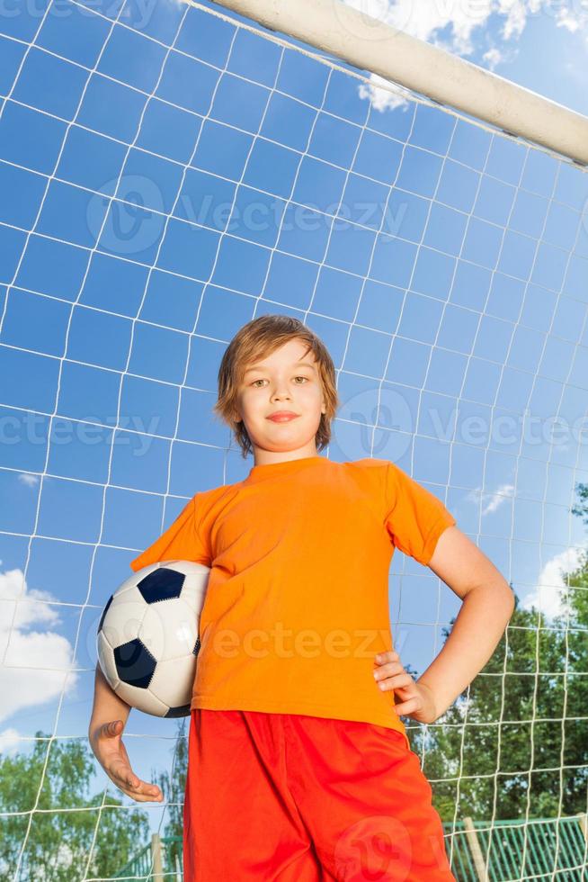 retrato de menino de uniforme com futebol foto