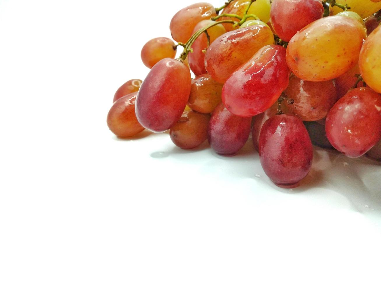 cacho de uvas vermelhas no conceito de fundo branco. consumo nutritivo de frutas e ajuda no controle de peso. dá uma sensação doce e azeda foto