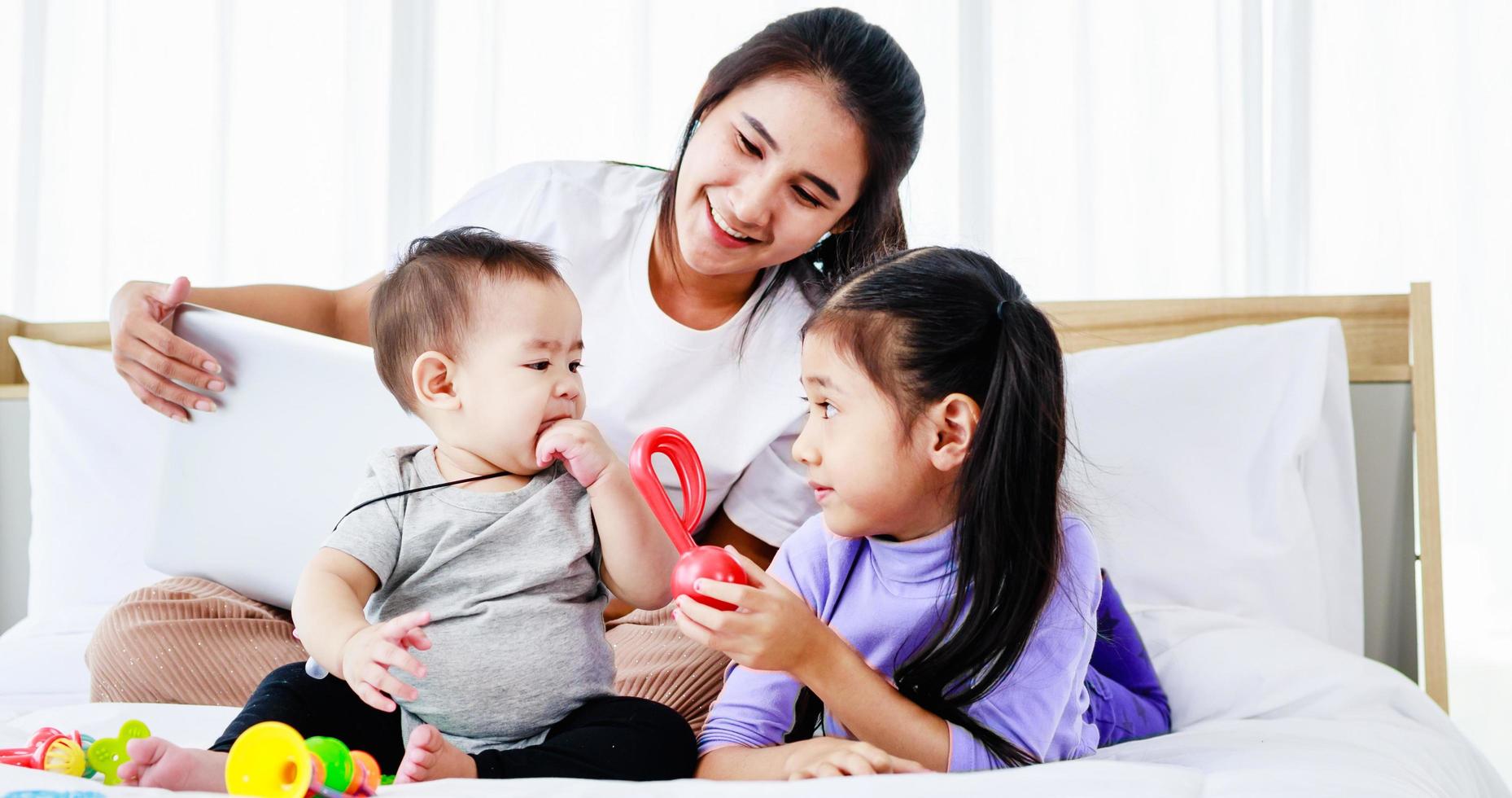 mãe solteira ocupada trabalhando freelance em casa e cuidando de seu bebê e filha foto