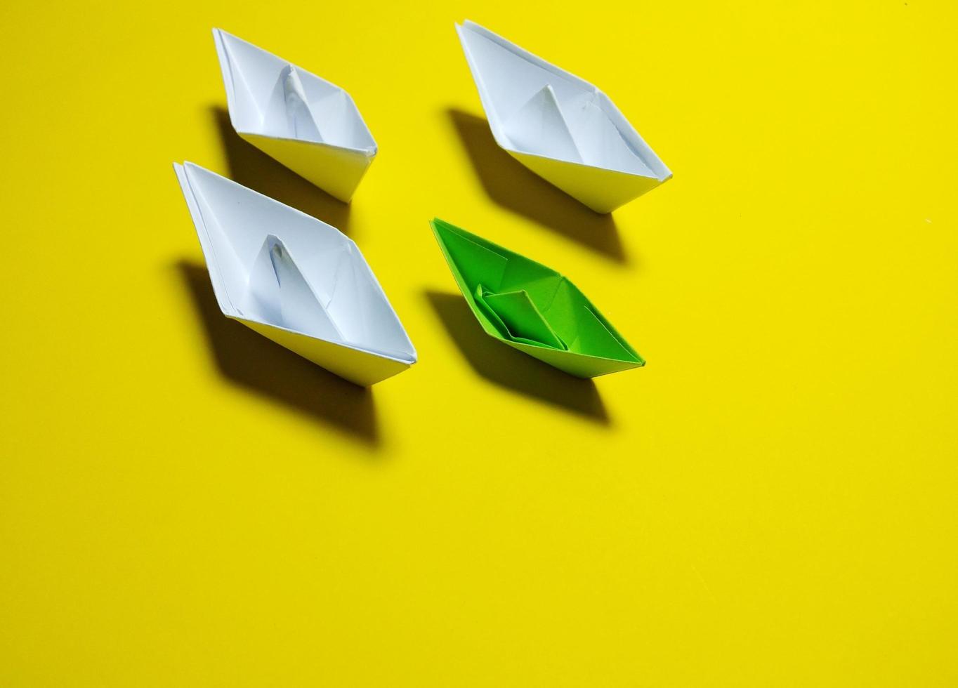 barco de papel branco e verde fundo amarelo de forma ordenada, fornecendo ideias, liderança e gestão eficaz dão um sentimento de solidariedade sucesso, amor, felicidade, grande foto