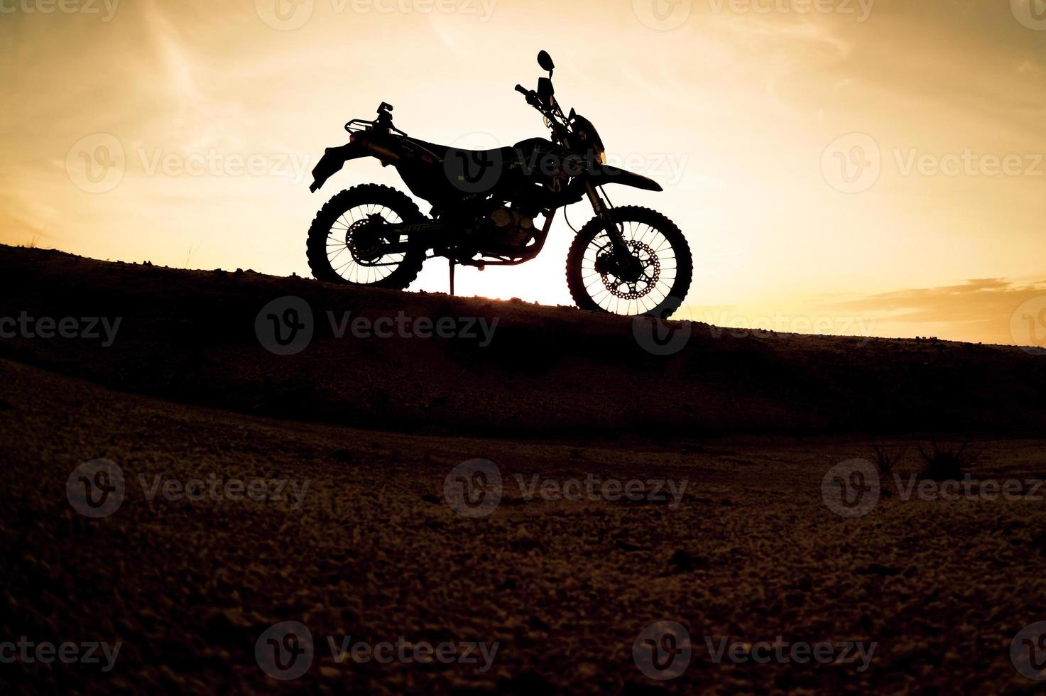 turista motocicleta motocross silhueta parque na montanha à noite. conceito de viagem de aventura foto