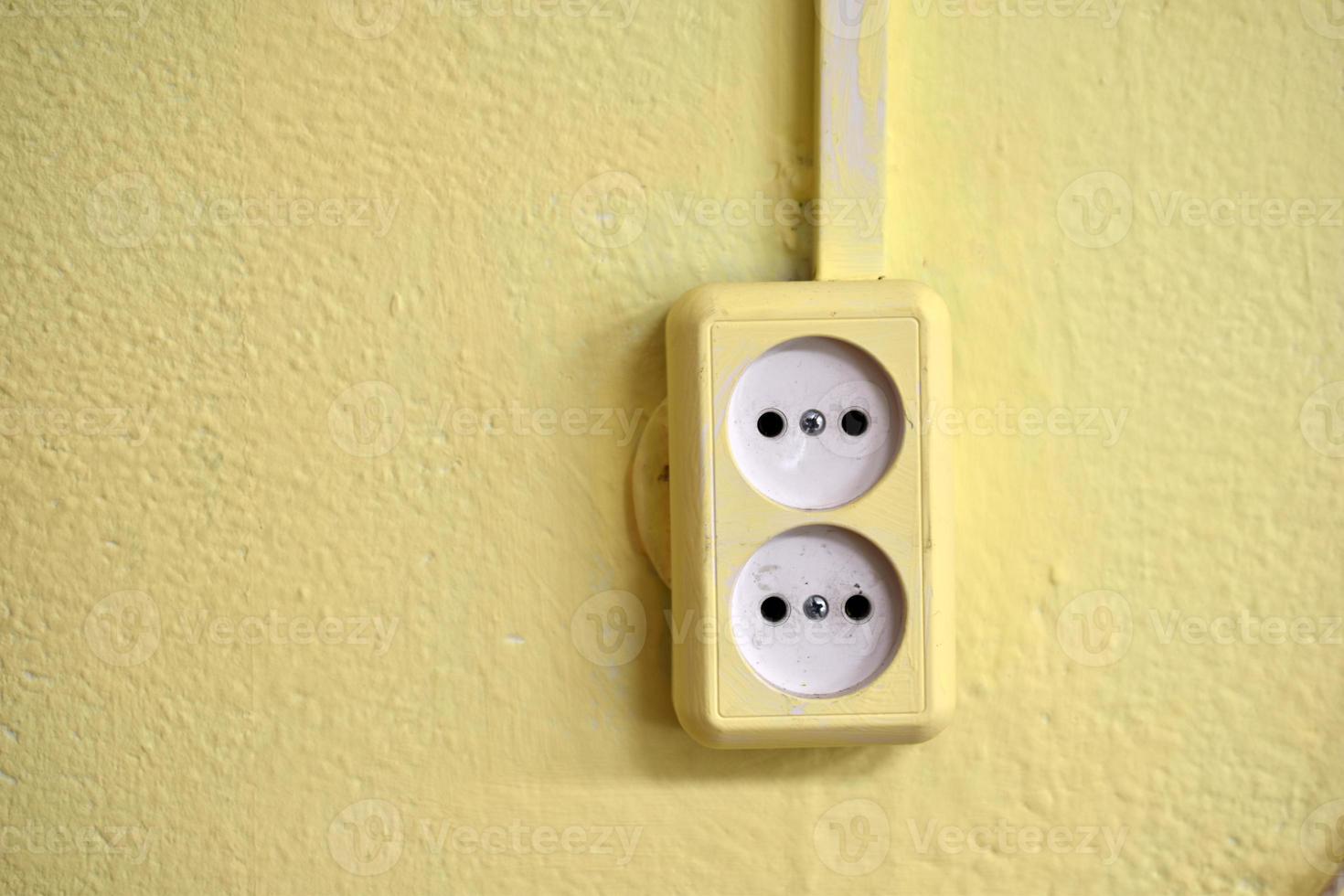 tomada elétrica na parede amarela da casa foto