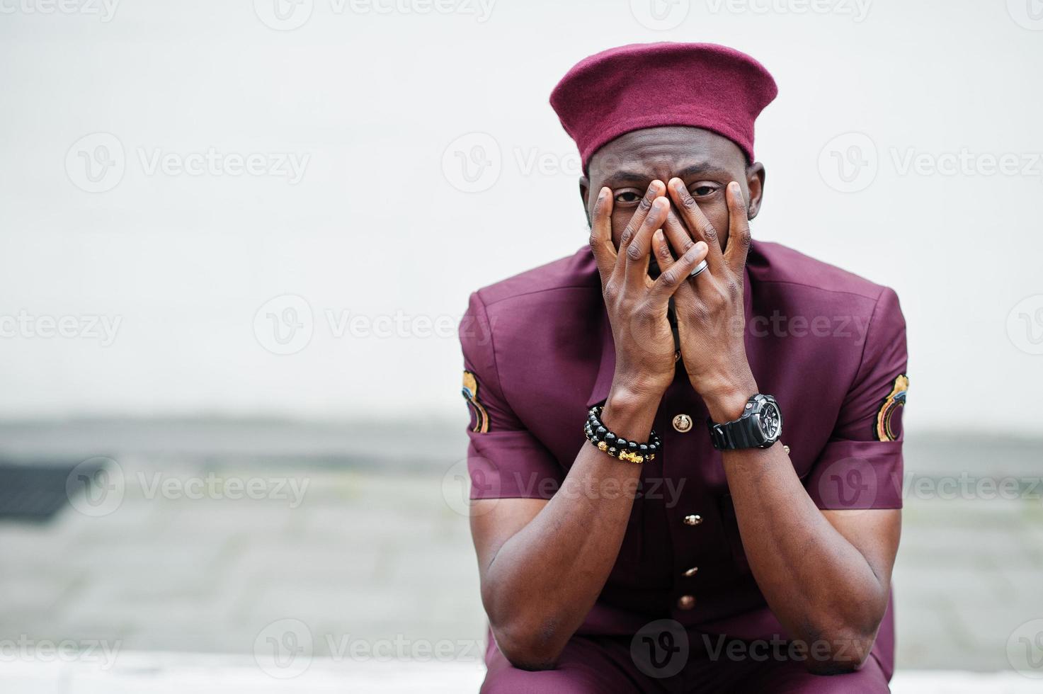 dor da guerra. retrato de militar americano africano em uniforme vermelho e boina cobre o rosto com as mãos. foto