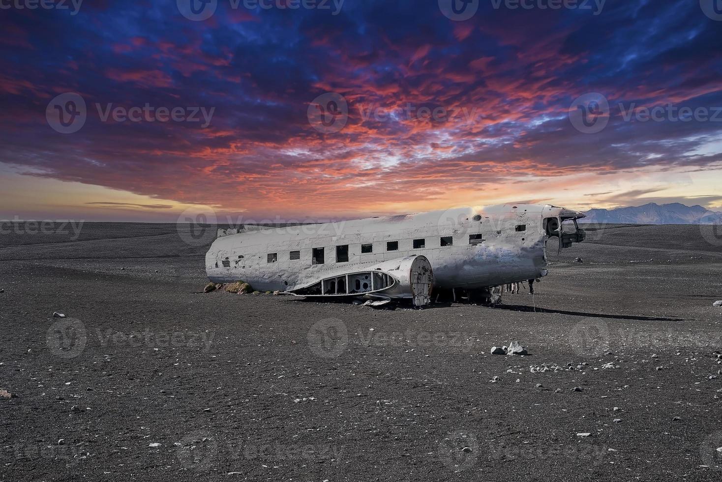 naufrágio de avião militar quebrado na praia de areia preta em solheimasandur ao pôr do sol foto