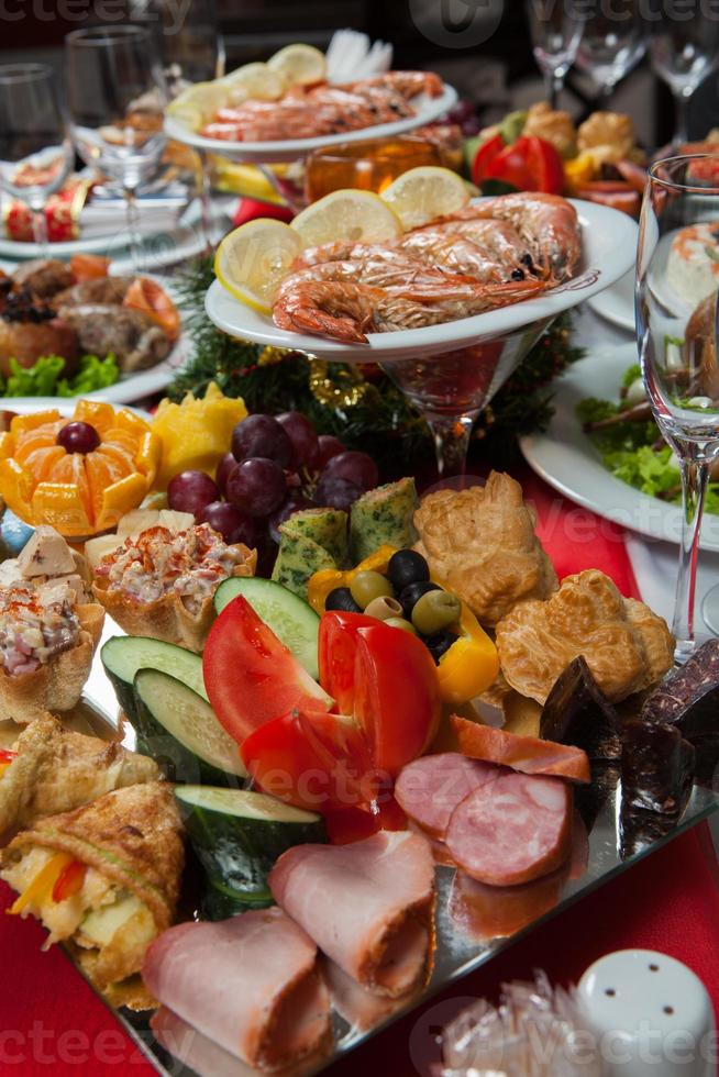 linda mesa festiva servida para jantar de festa de casamento em casa ou restaurante interior. mesa cheia de comida em um restaurante. mesa redonda completa. foto