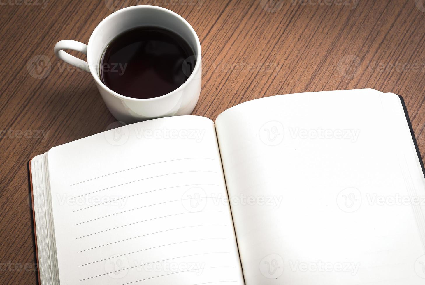 caderno vazio e café na mesa de madeira foto
