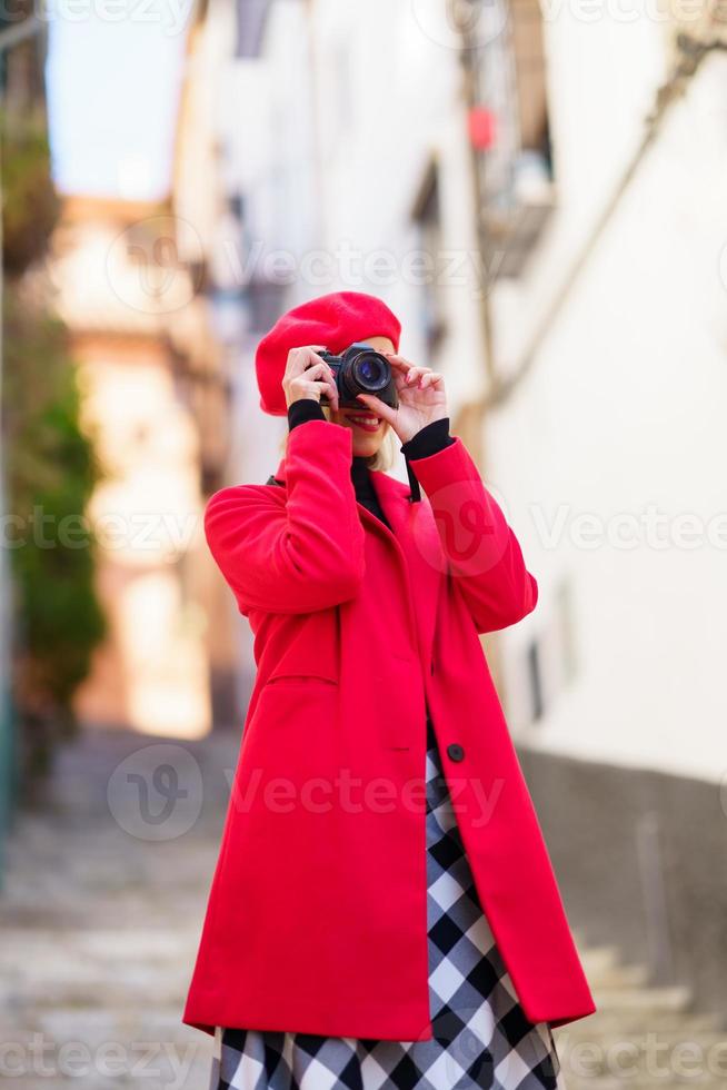 mulher sorridente tirando fotos na câmera fotográfica durante as férias