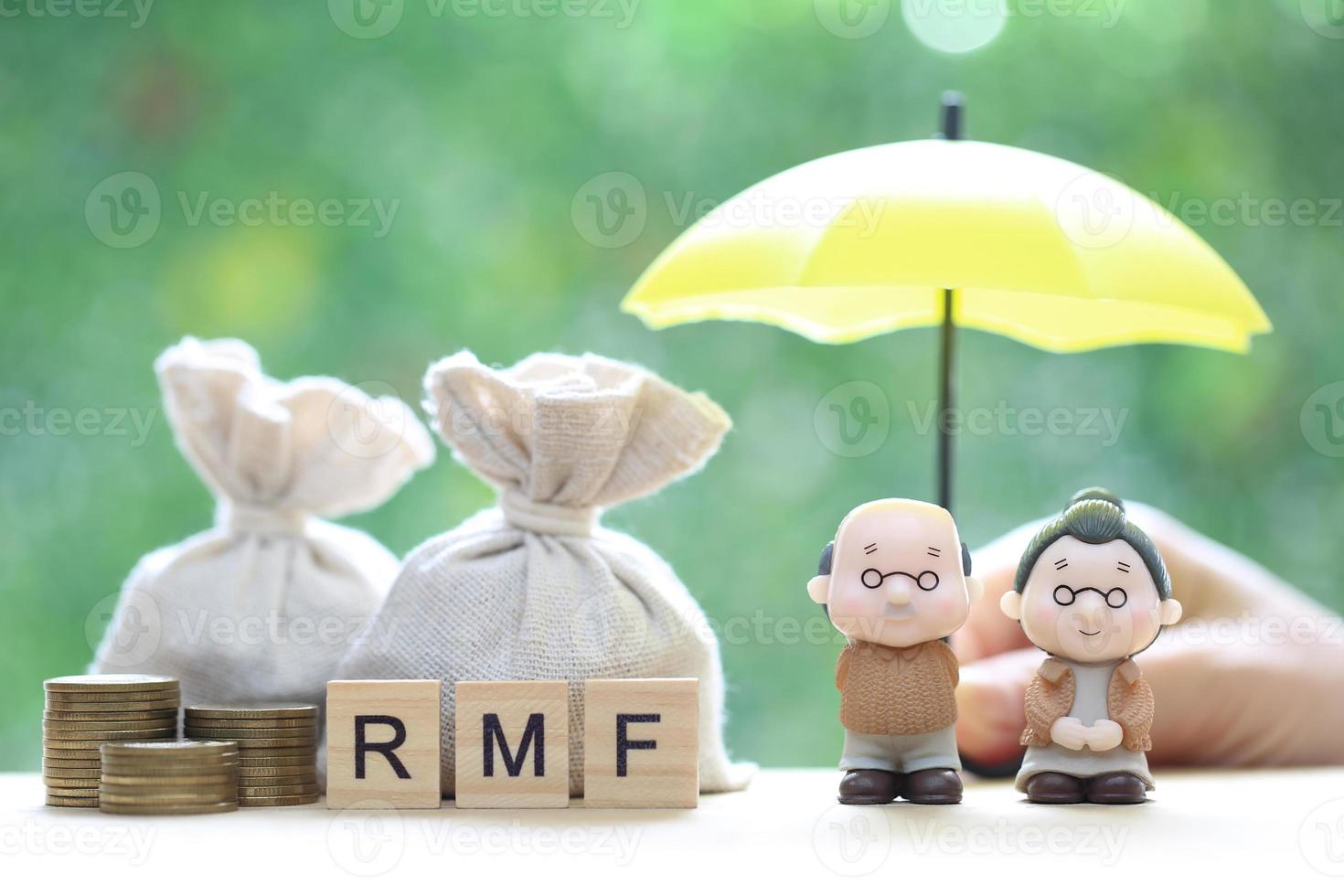 fundo mútuo, amor casal sênior e mão segurando o guarda-chuva com pilha de moedas dinheiro em fundo verde natural, economizar dinheiro para preparar no futuro e conceito de aposentadoria foto