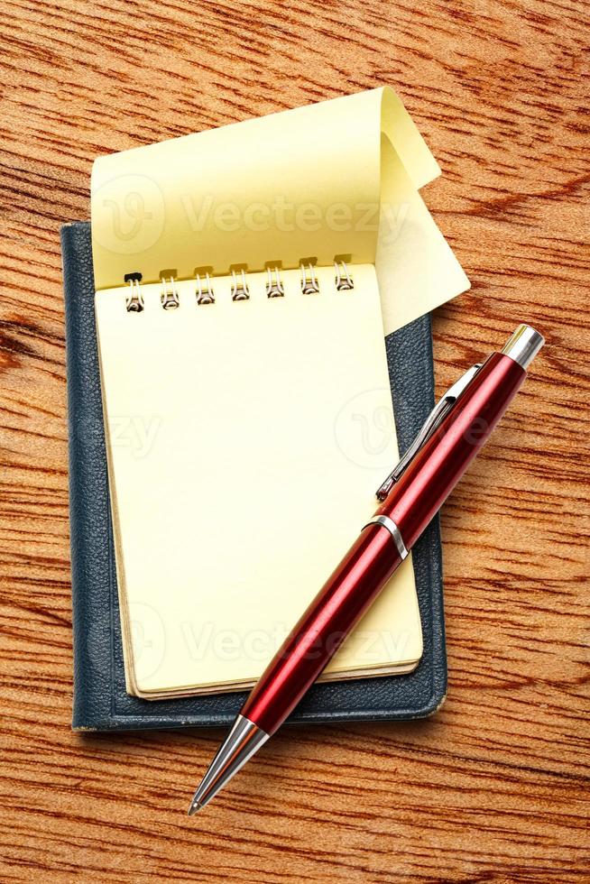 bloco de notas em branco amarelo com caneta foto