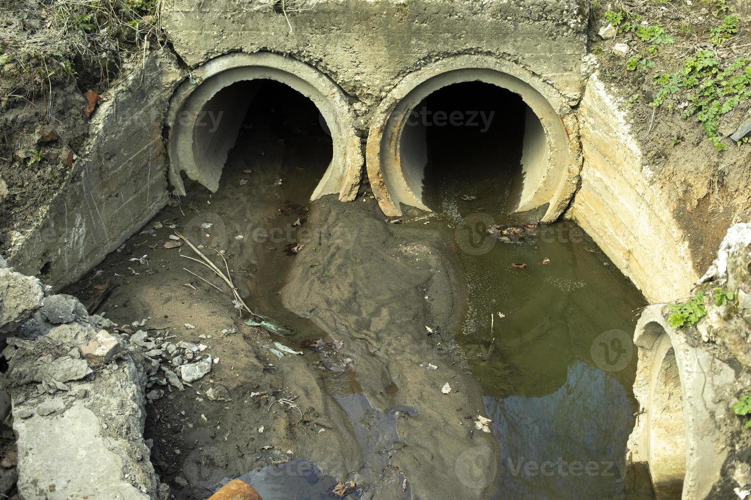 tubos drenam resíduos. esgoto na cidade. tubos de concreto no solo. foto