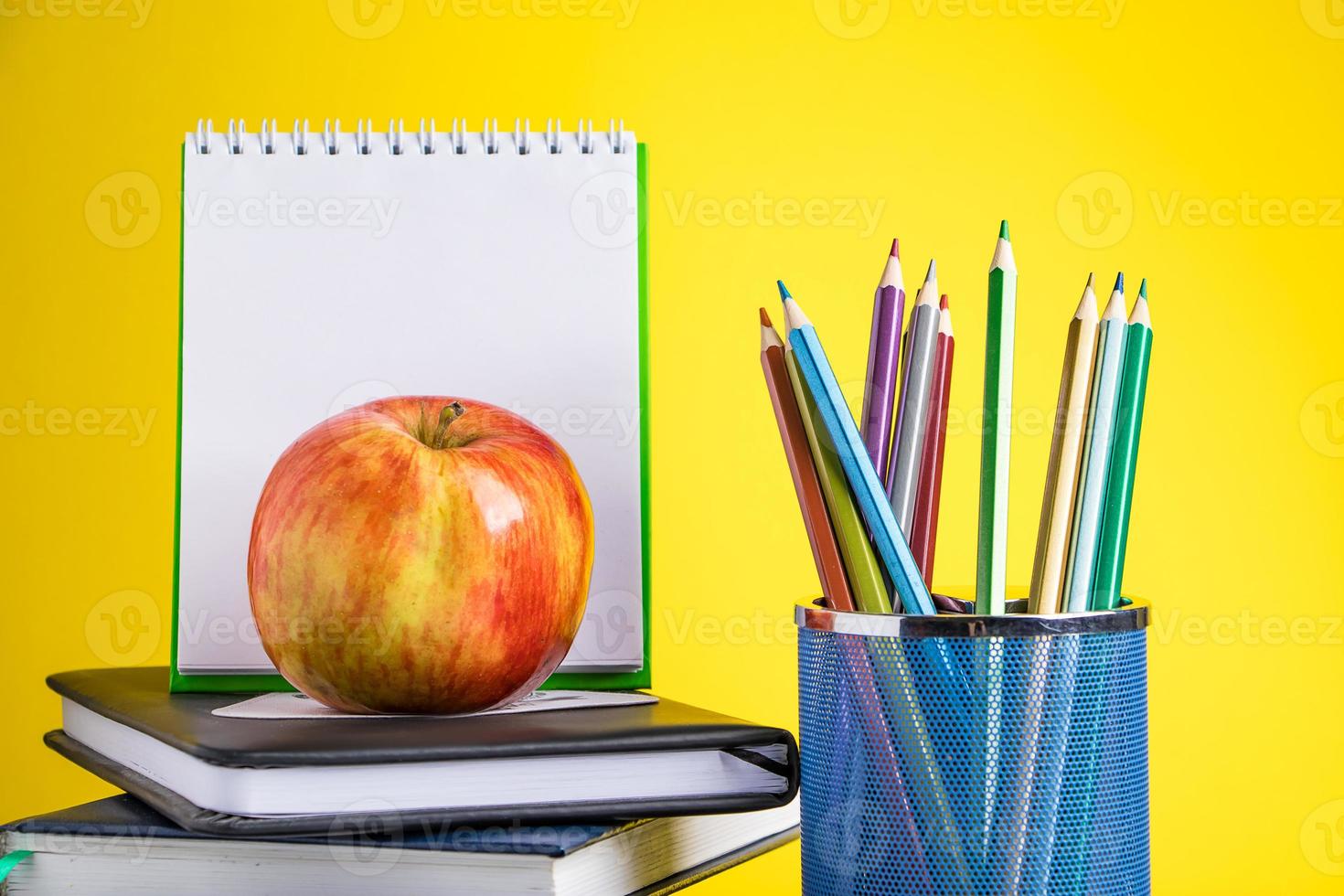 de volta ao conceito de escola. material escolar e livros sobre fundo amarelo. lugar para texto. foto