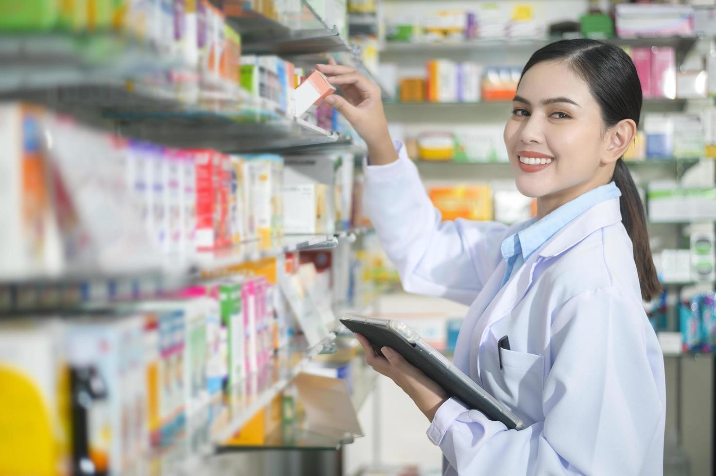 retrato de farmacêutico feminino usando tablet em uma farmácia de farmácia moderna. foto