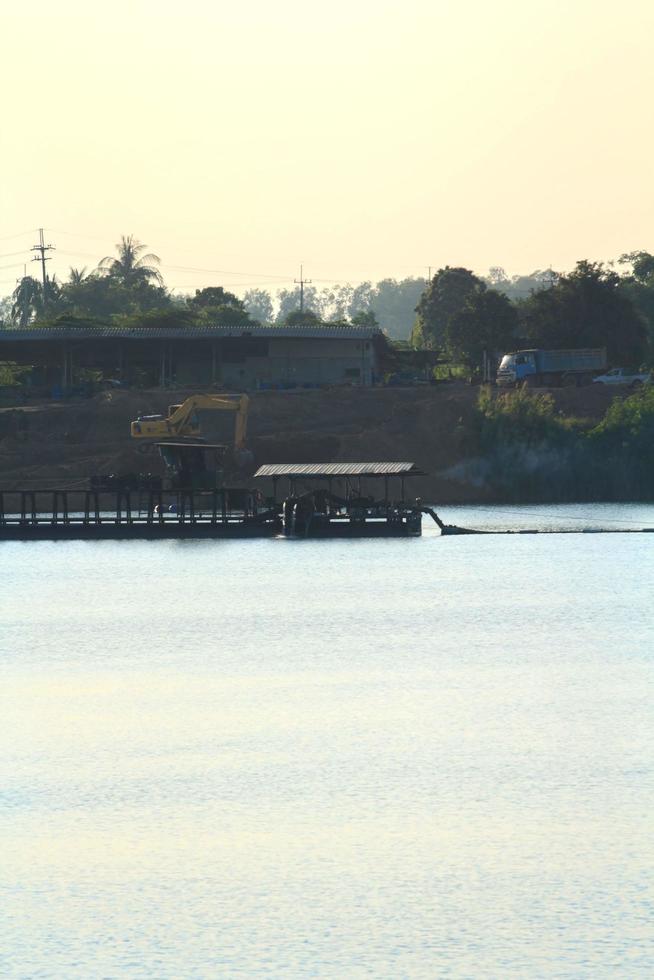 as embarcações de sucção de areia estão transportando areia de tubos de aço em rios profundos para a construção de indústrias como casas, prédios, estradas e muitas outras onde a areia é usada como mistura. foto