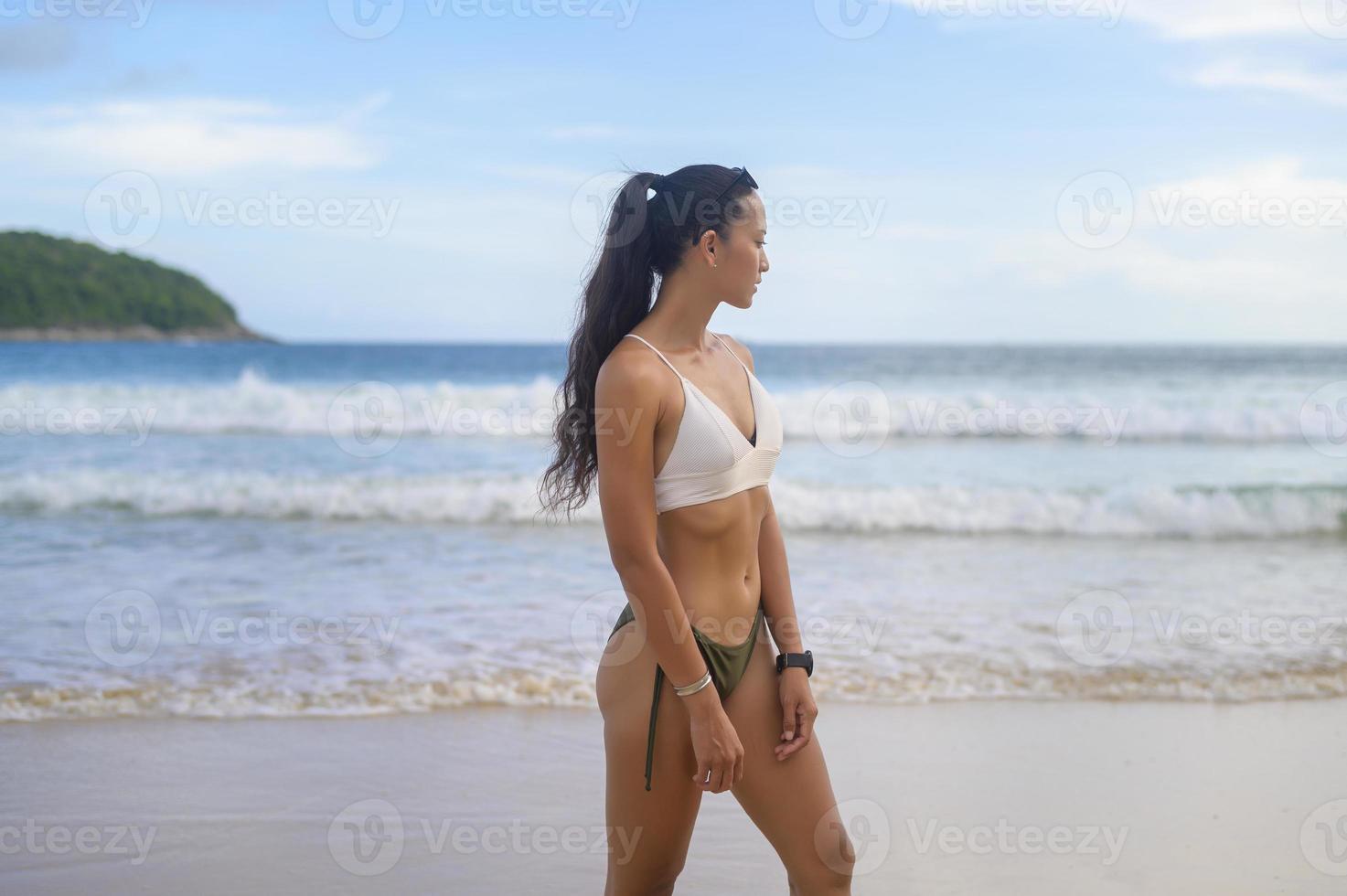 jovem mulher bonita de biquíni curtindo e relaxando na praia, verão, férias, feriados, conceito de estilos de vida. foto